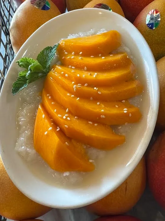 Thai mango sticky rice with sliced mango and sesame seeds