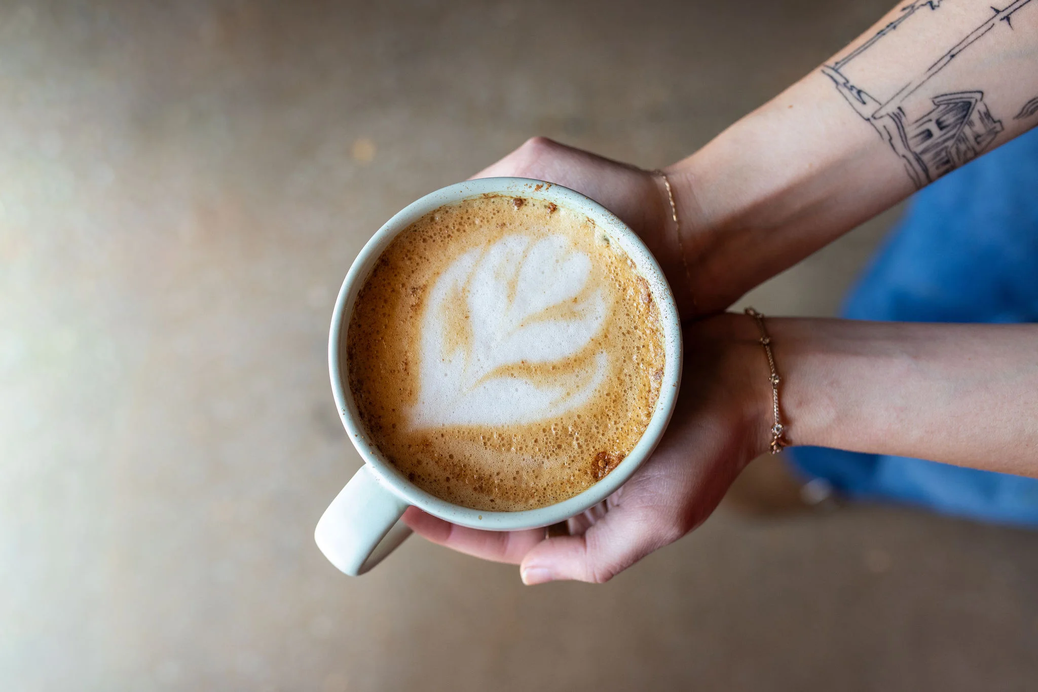 Artisan latte with leaf design in a cozy café setting