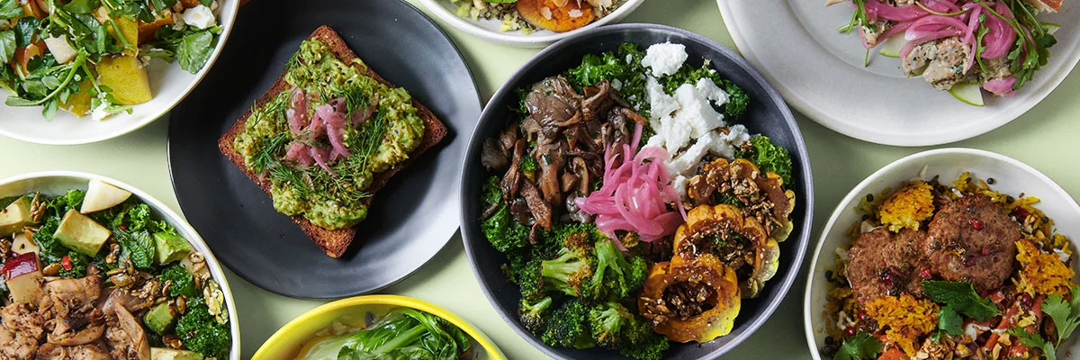 Colorful modern Mediterranean restaurant spread with grain bowls, avocado toast, and roasted vegetables