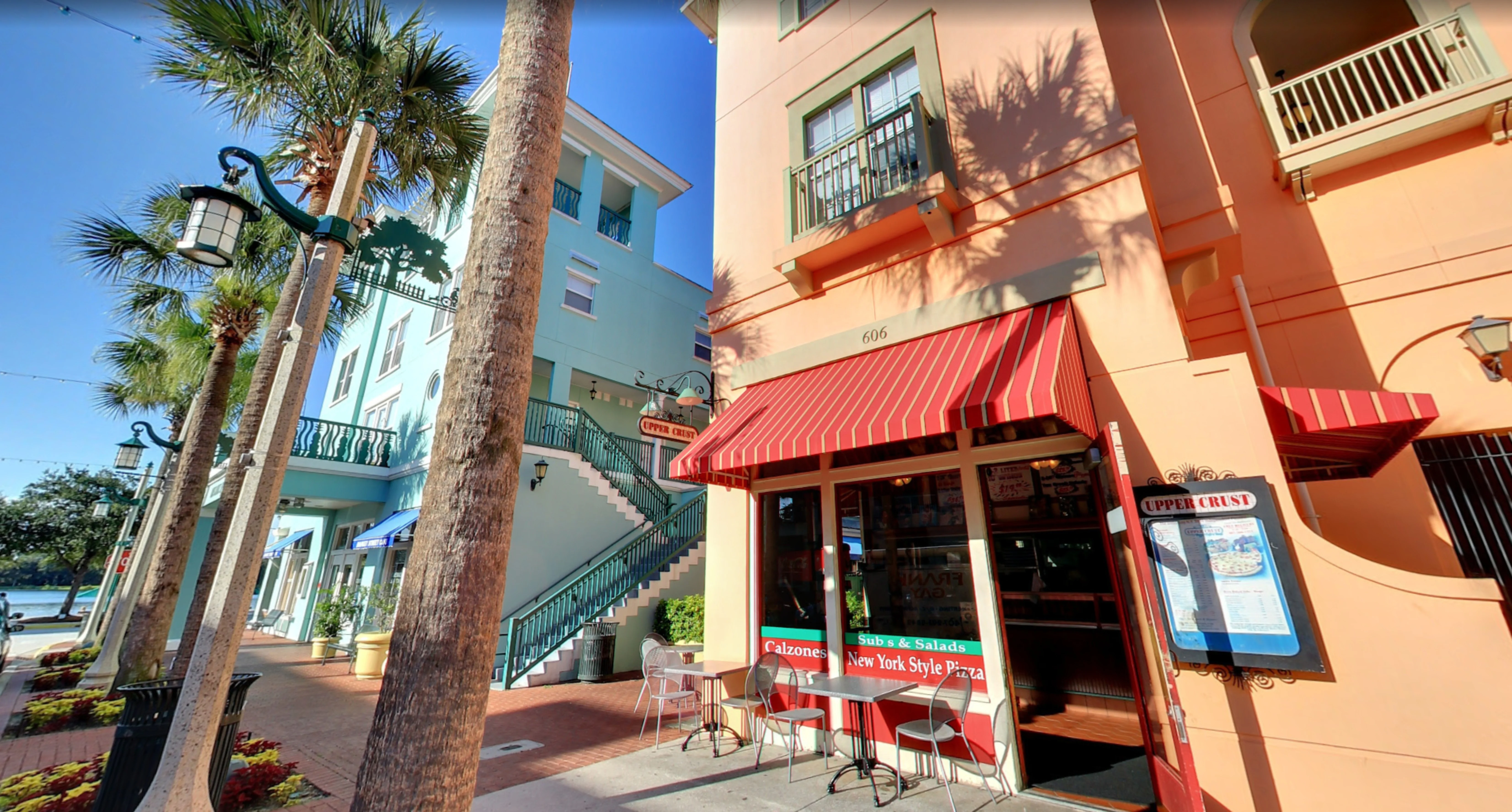 Exterior view of a modern restaurant with outdoor seating and vibrant signage.