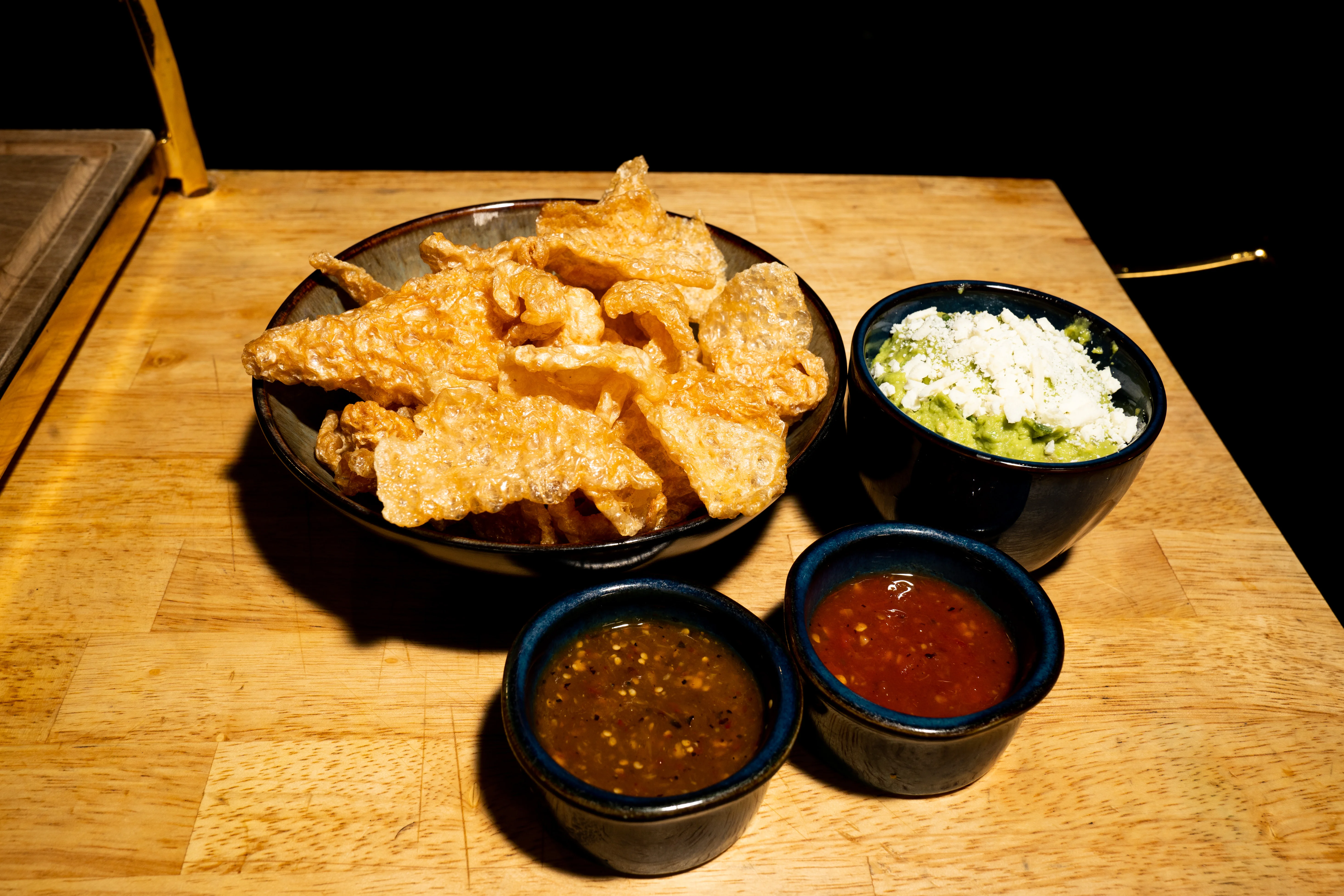 Crispy pork rinds with guacamole and salsas