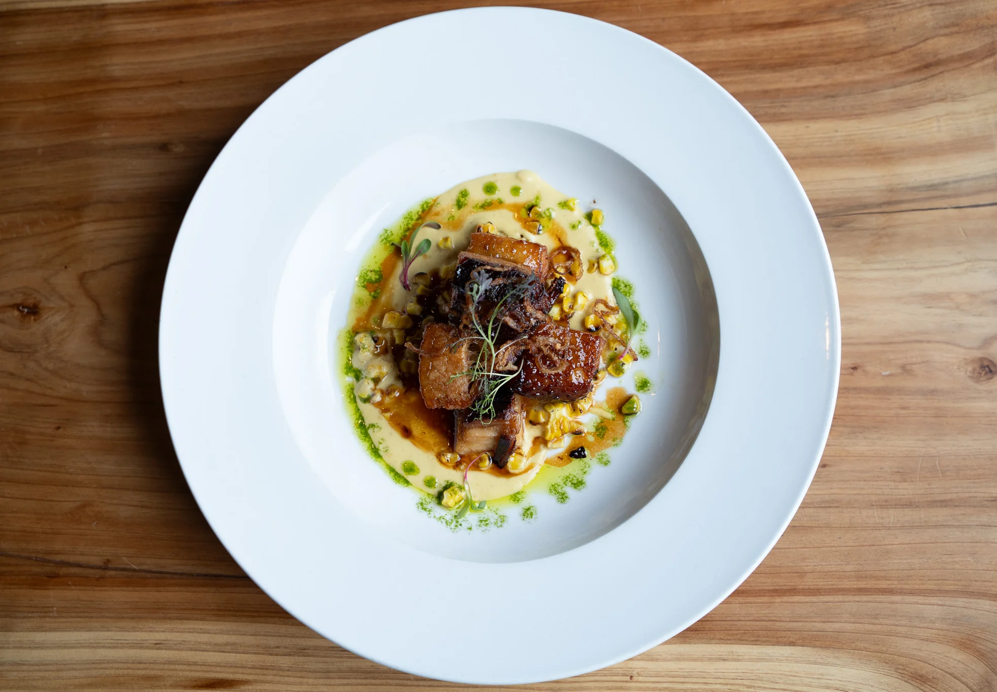 Crispy pork belly with corn puree, a modern American dish
