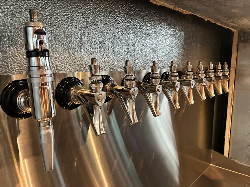 Row of shiny beer taps at a modern bar