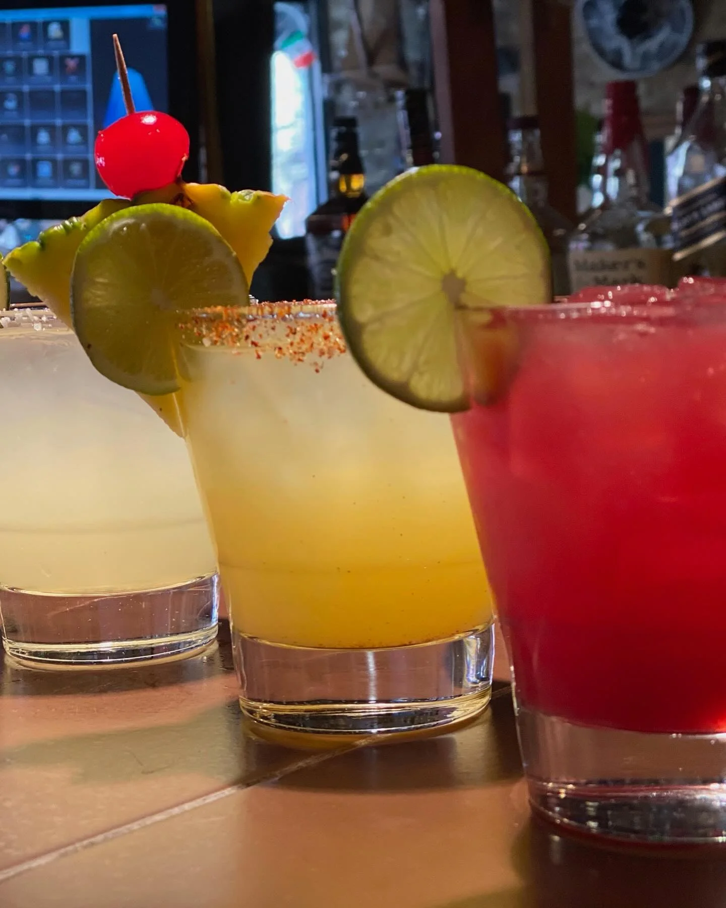 Colorful cocktails with garnishes at a lively bar