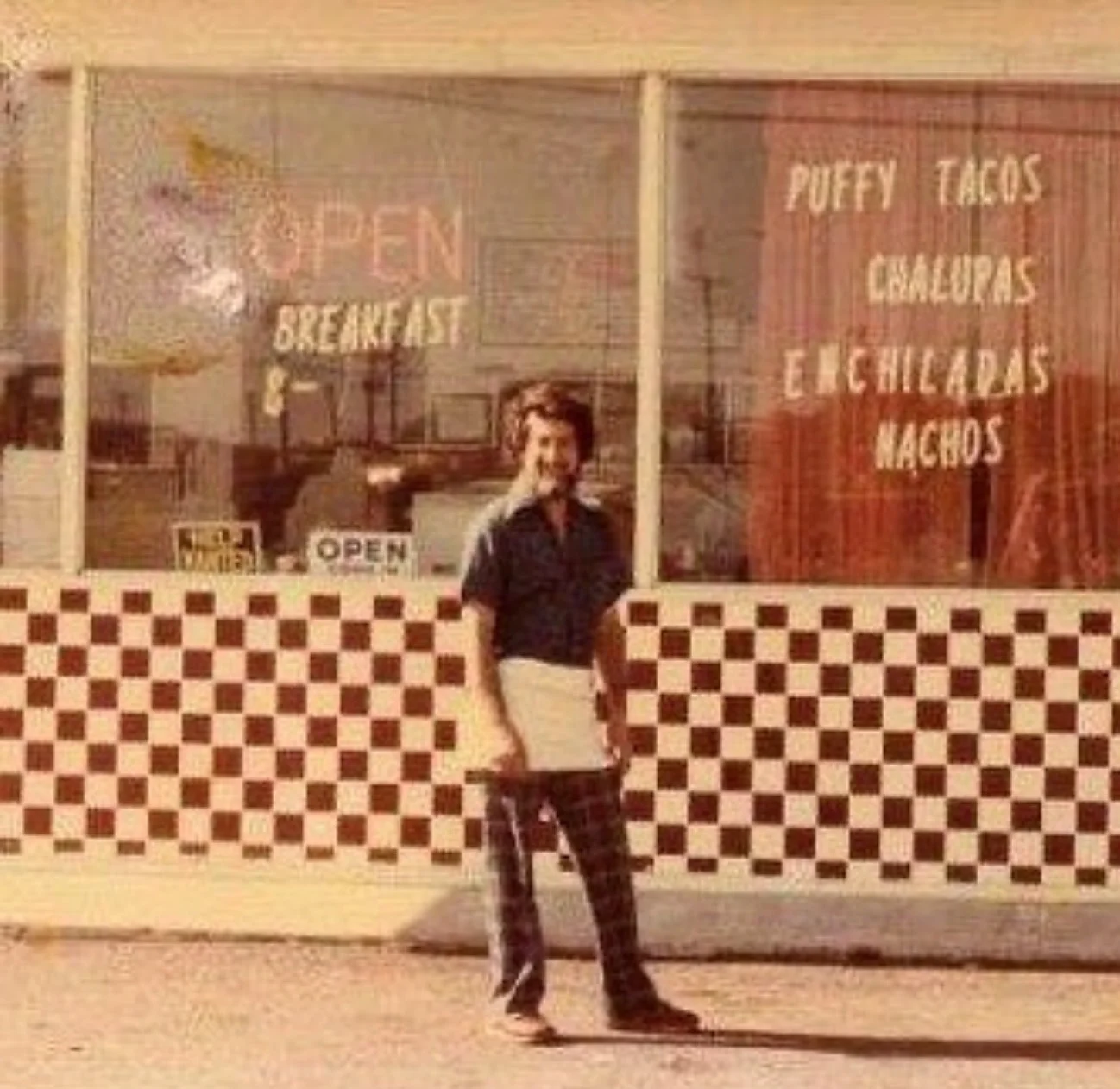 Restaurant exterior showcasing puffy tacos and enchiladas with checkered pattern
