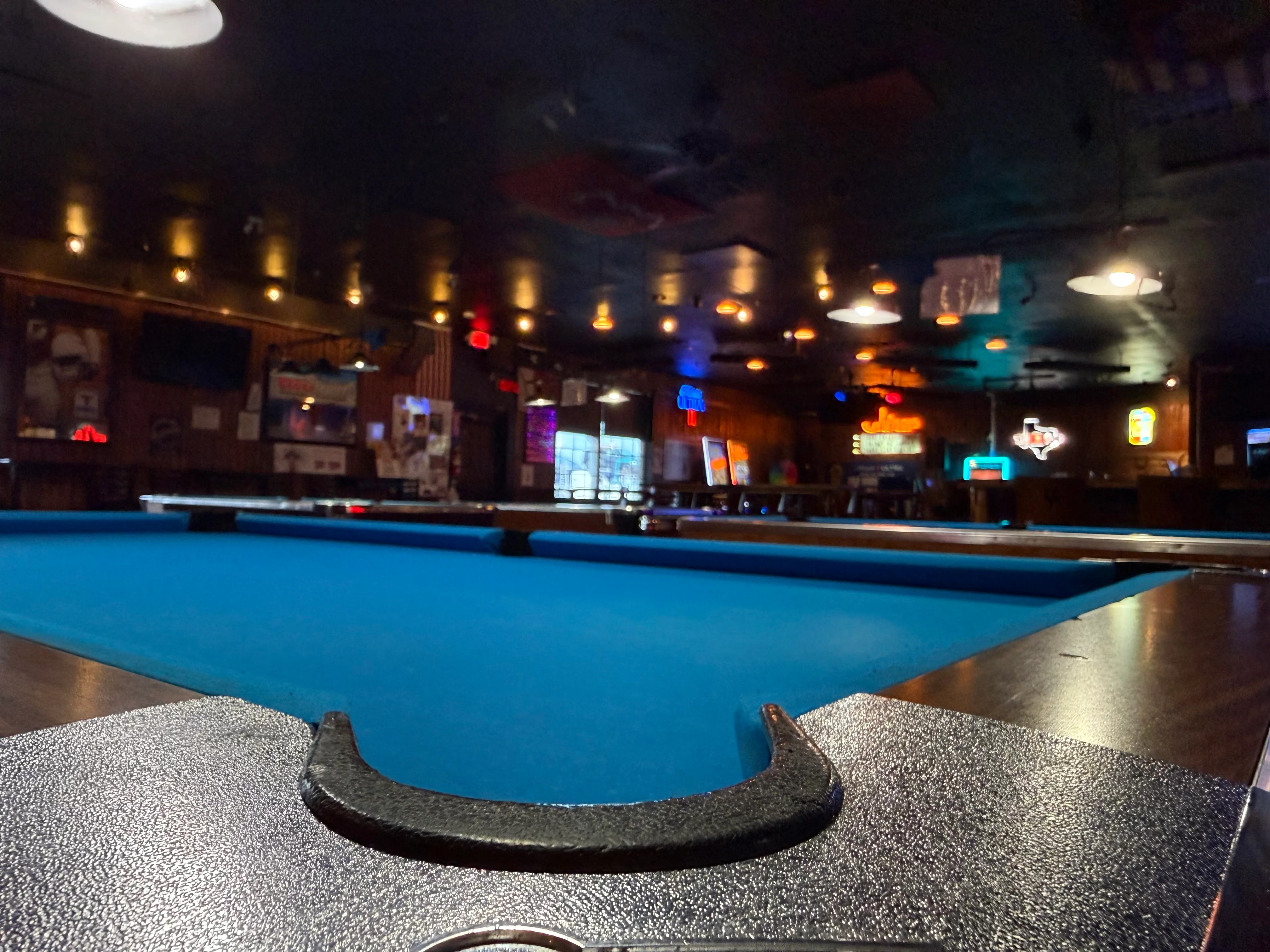 Interior of a lively bar featuring a blue pool table