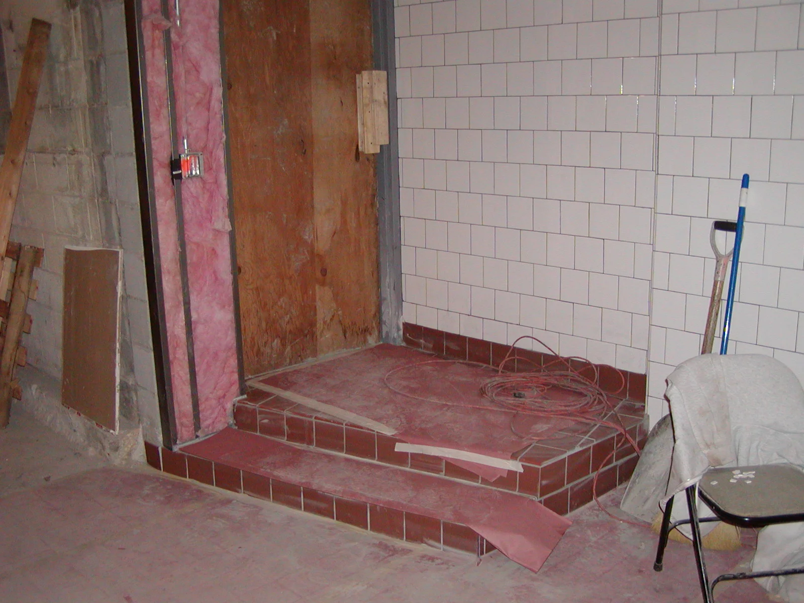 Under-construction restaurant interior with tiled steps and exposed walls