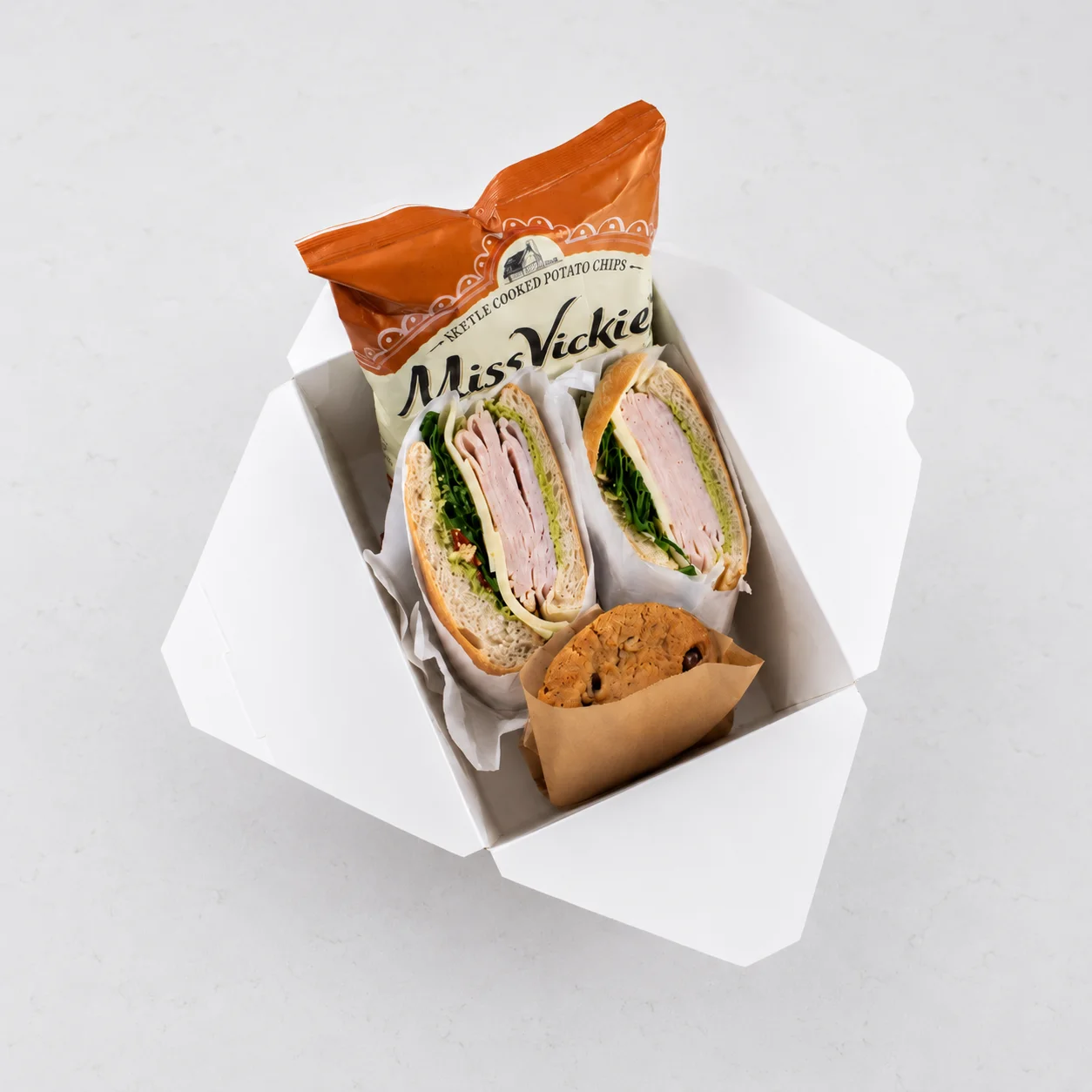 Office 842 boxed lunch with Turkey Pesto sandwich, kettle chips, and chocolate chip cookie