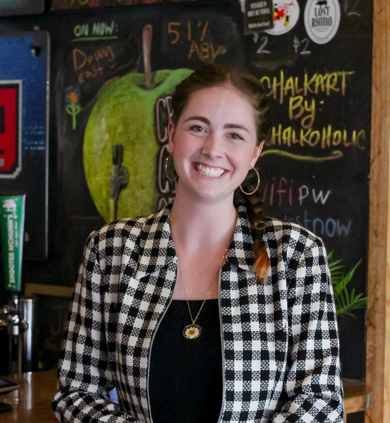Friendly bartender smiling at a vibrant bar counter