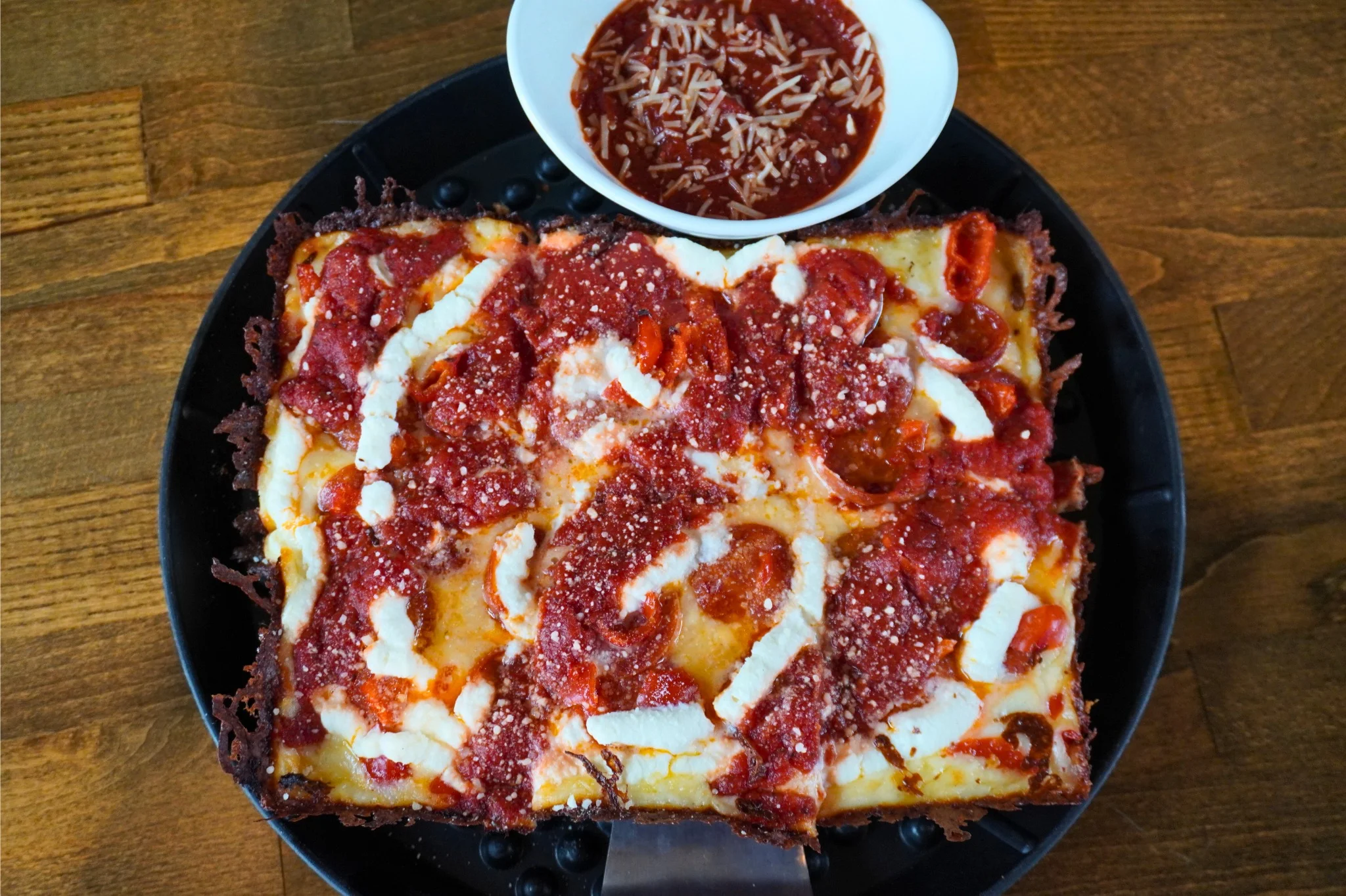 Deep-dish pepperoni pizza with marinara sauce