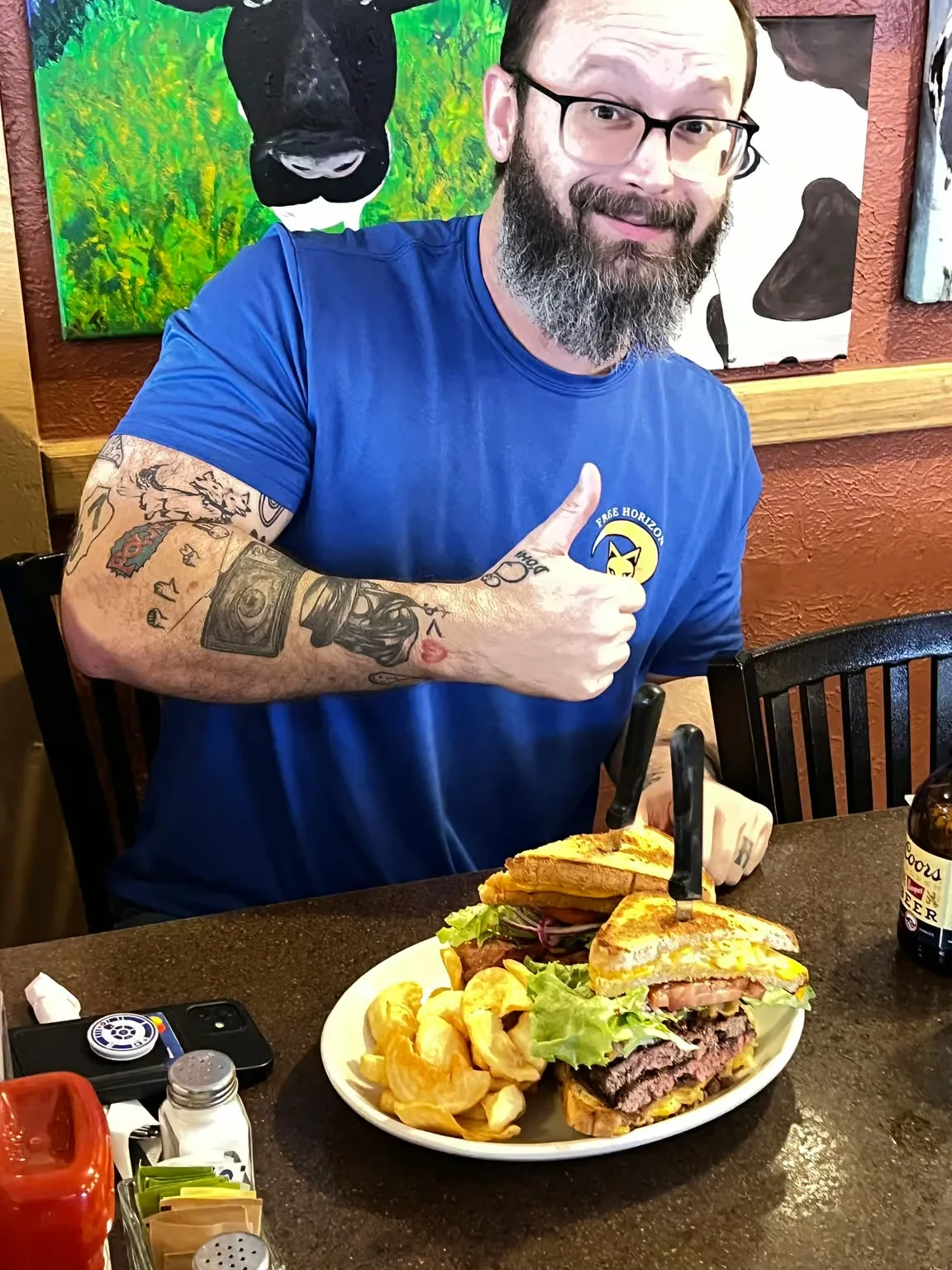 Giant cheeseburger with fries in a cozy restaurant setting