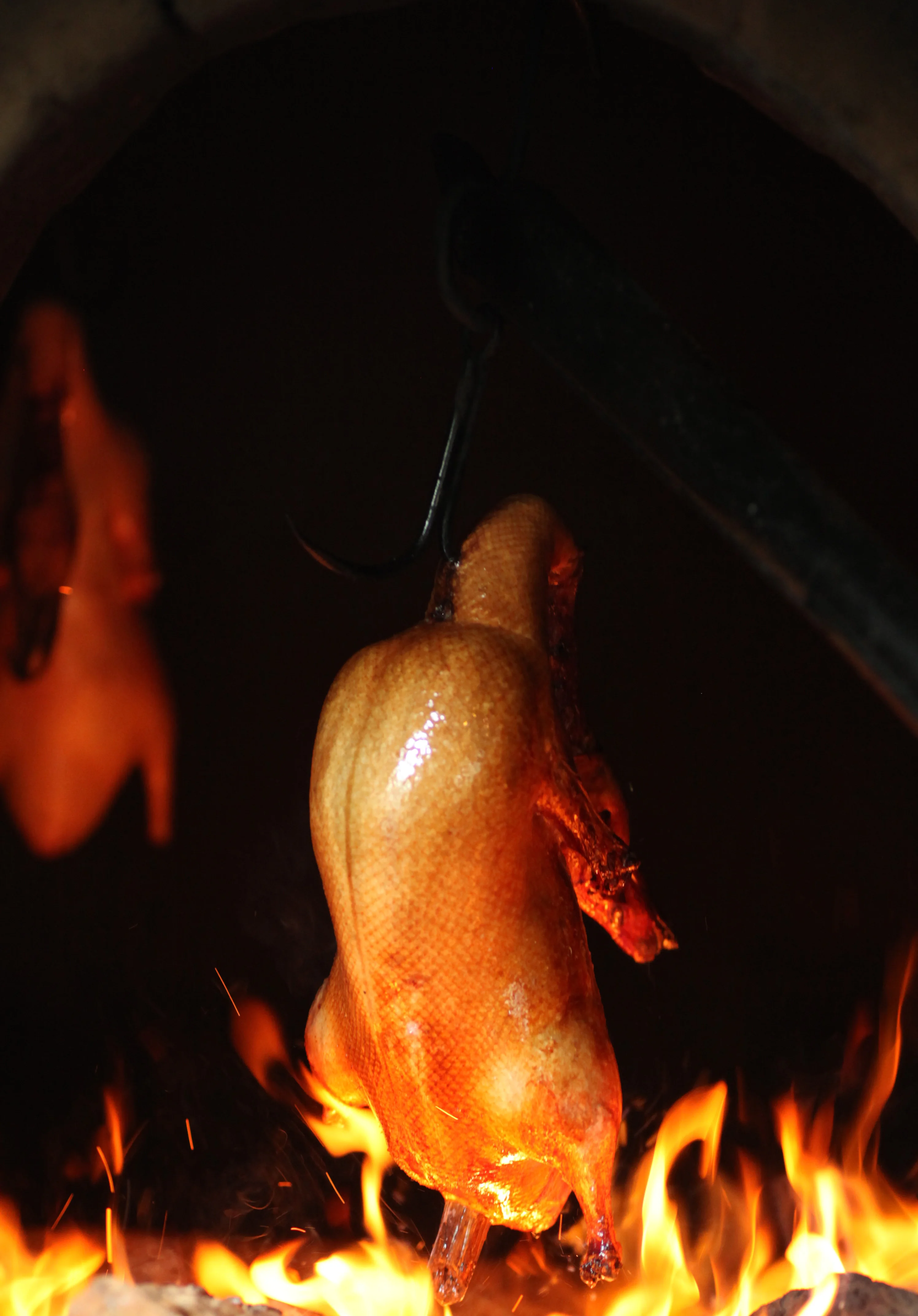Peking duck roasting over an open flame