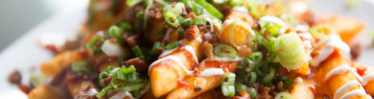 Loaded Canadian poutine topped with green onions