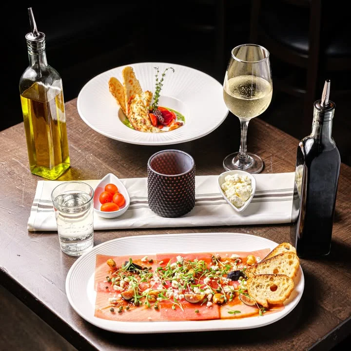 Italian carpaccio served with garnishes and wine