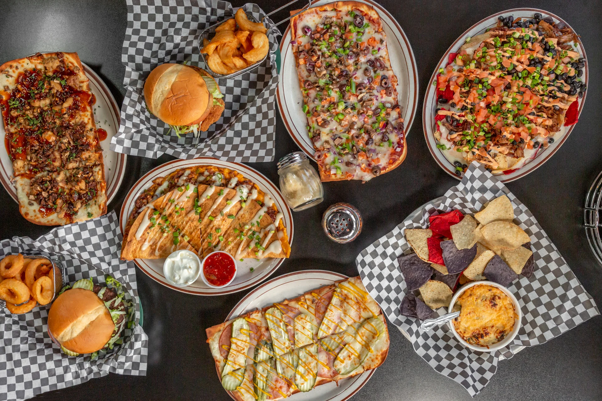 Variety of American comfort food platters with burgers and nachos