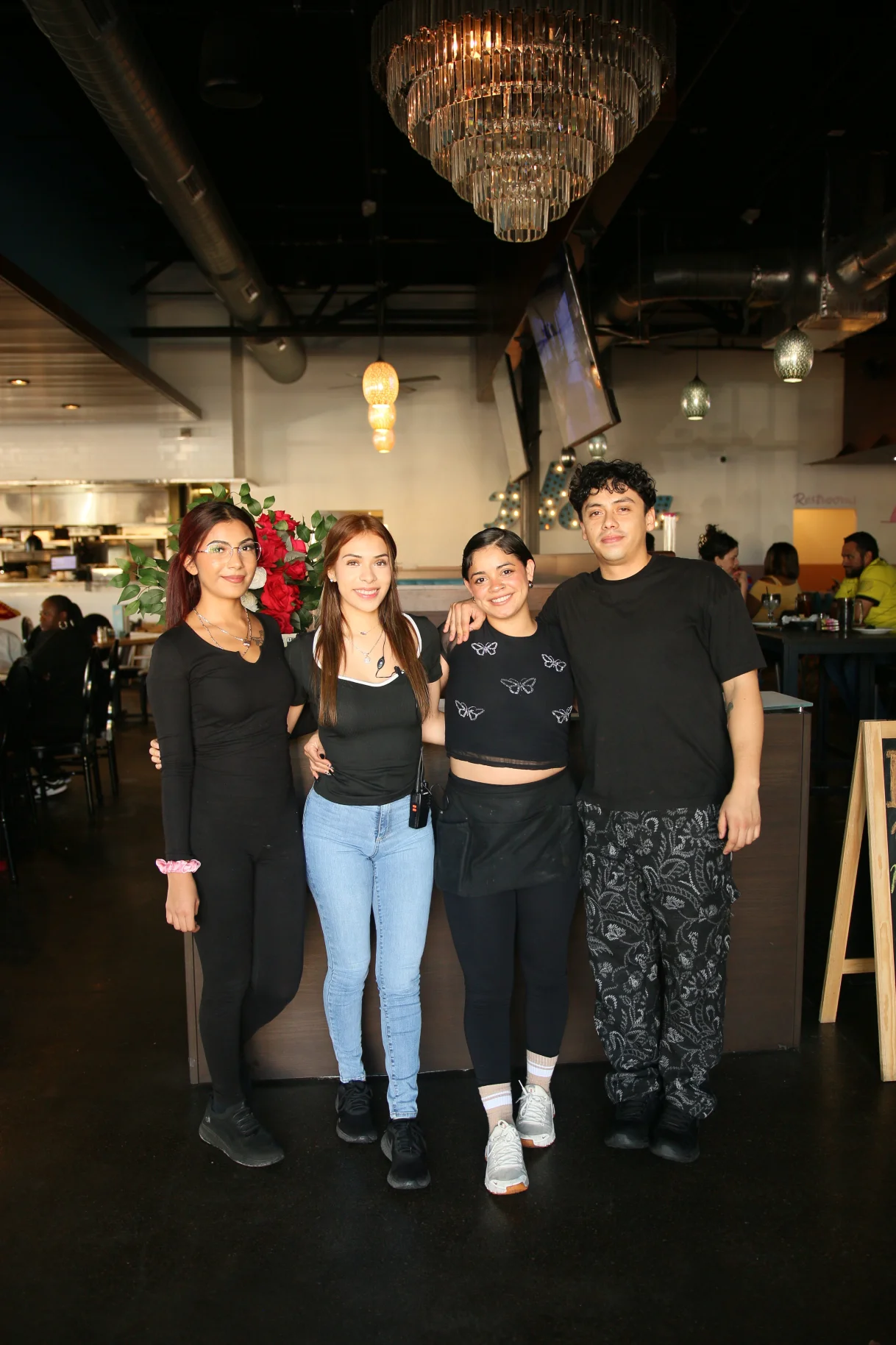 Friendly restaurant staff posing together in a modern dining space