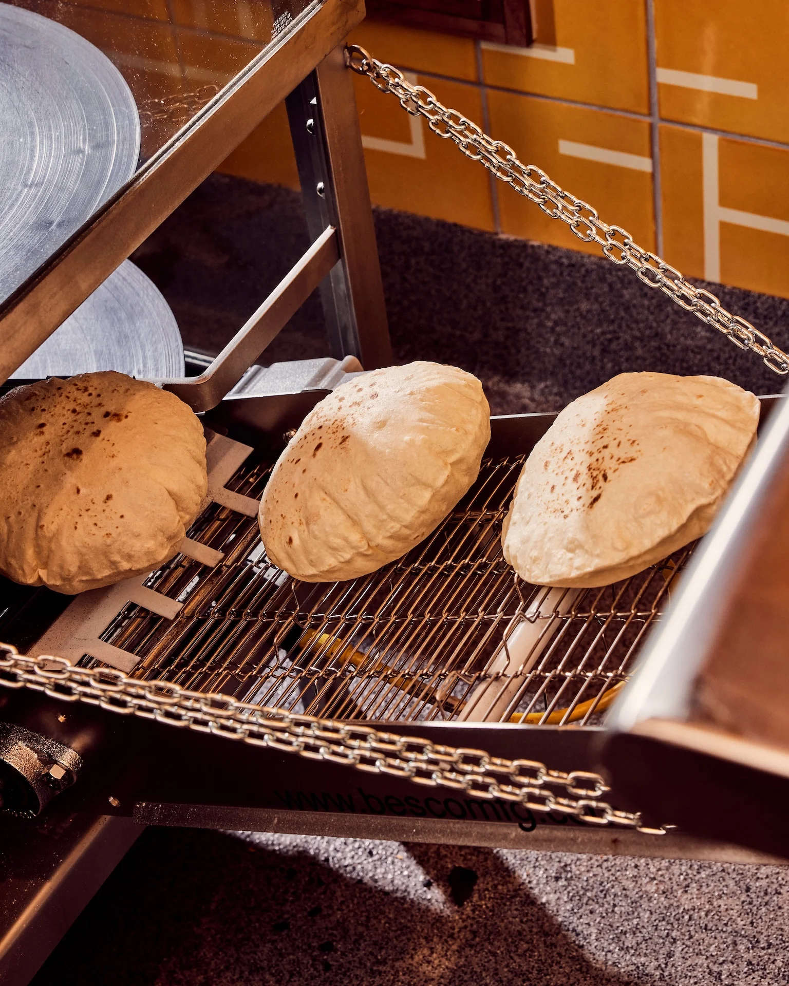 Freshly baked naan bread cooling on a rack