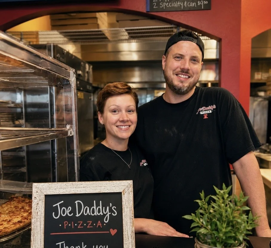 Friendly staff at Joe Daddy's Pizza with a thank you sign