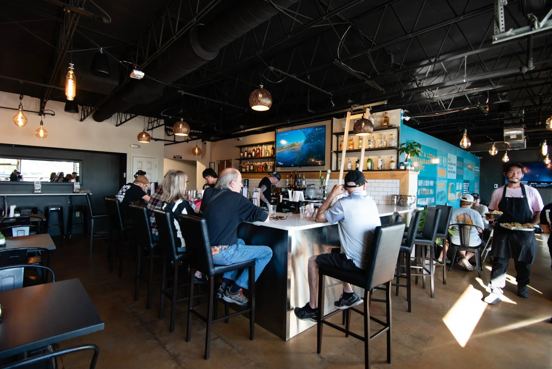 Modern restaurant interior with bar seating and warm lighting
