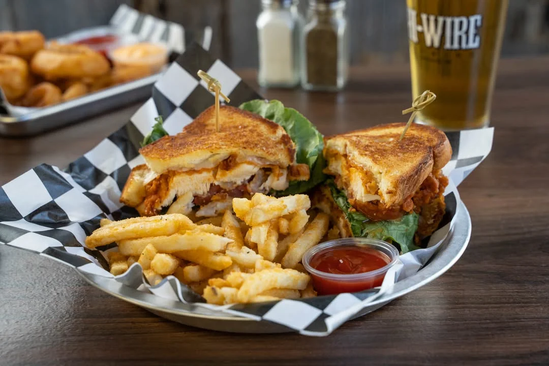Crispy chicken sandwich with fries and dipping sauce in a casual dining setting