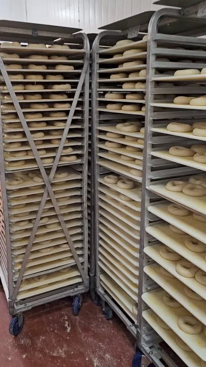 Racks of freshly shaped bagels ready for baking