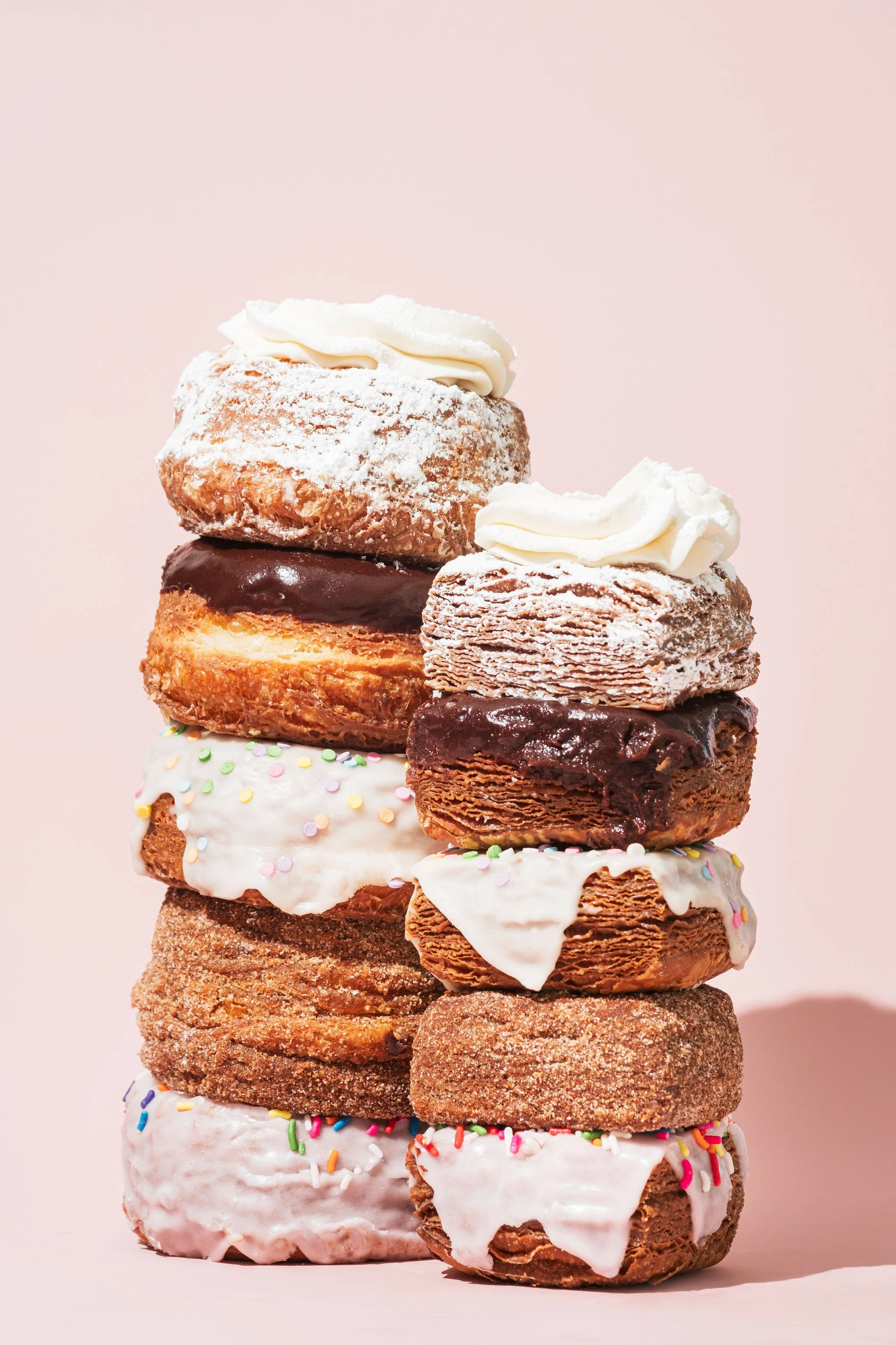Stack of colorful gourmet donuts with frosting and sprinkles