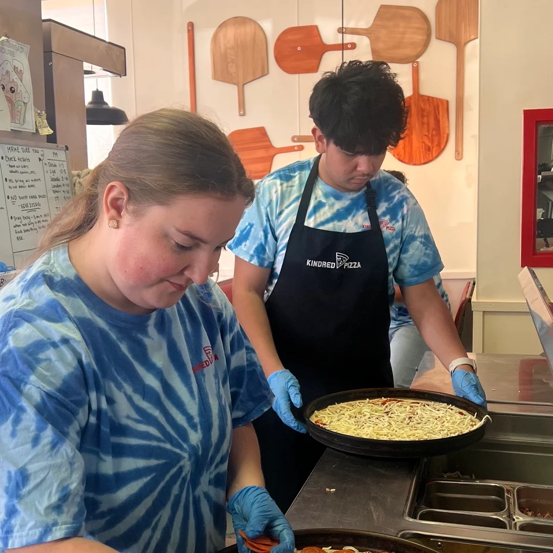 Pizza preparation with pepperoni and cheese at a pizzeria
