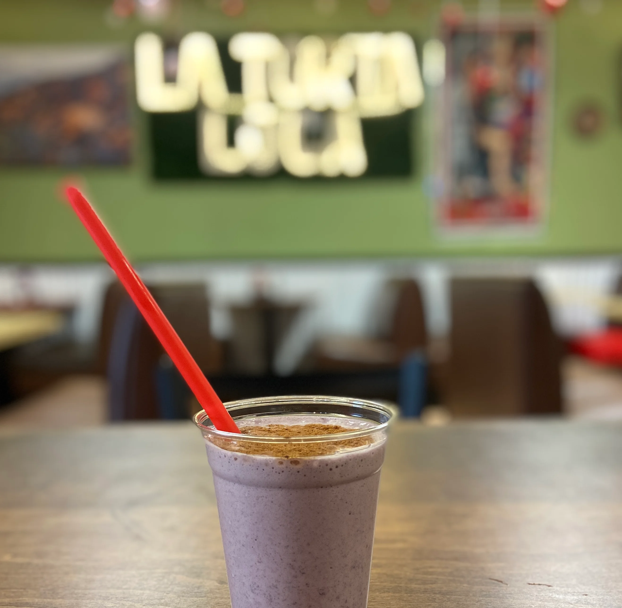 Refreshing berry smoothie in a clear cup with a red straw