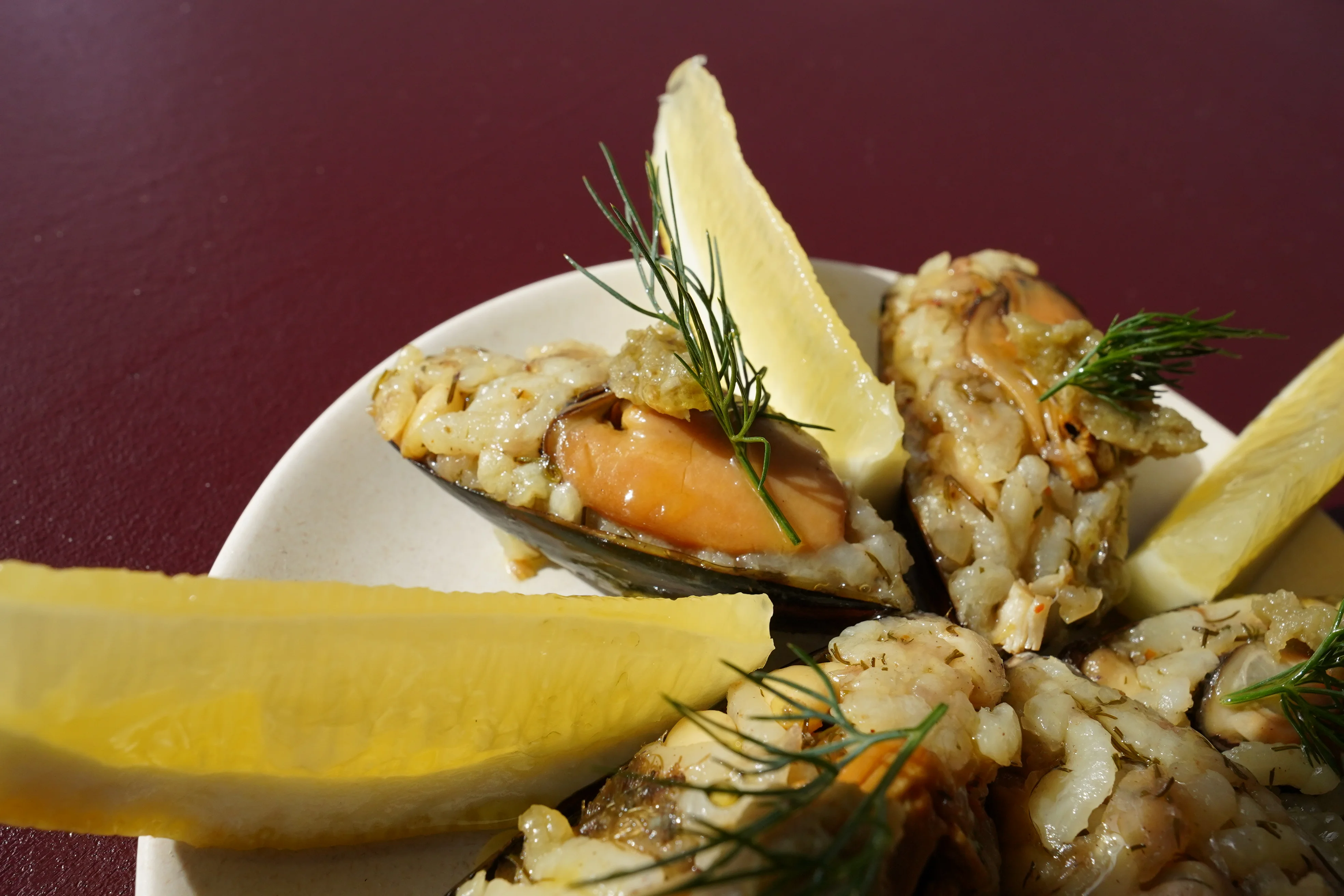 Baked mussels with herbs and lemon wedges