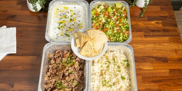 Mediterranean platter with grilled meat, rice, salad, and pita bread