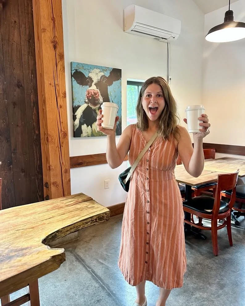 Happy customer holding coffee cups in a cozy café