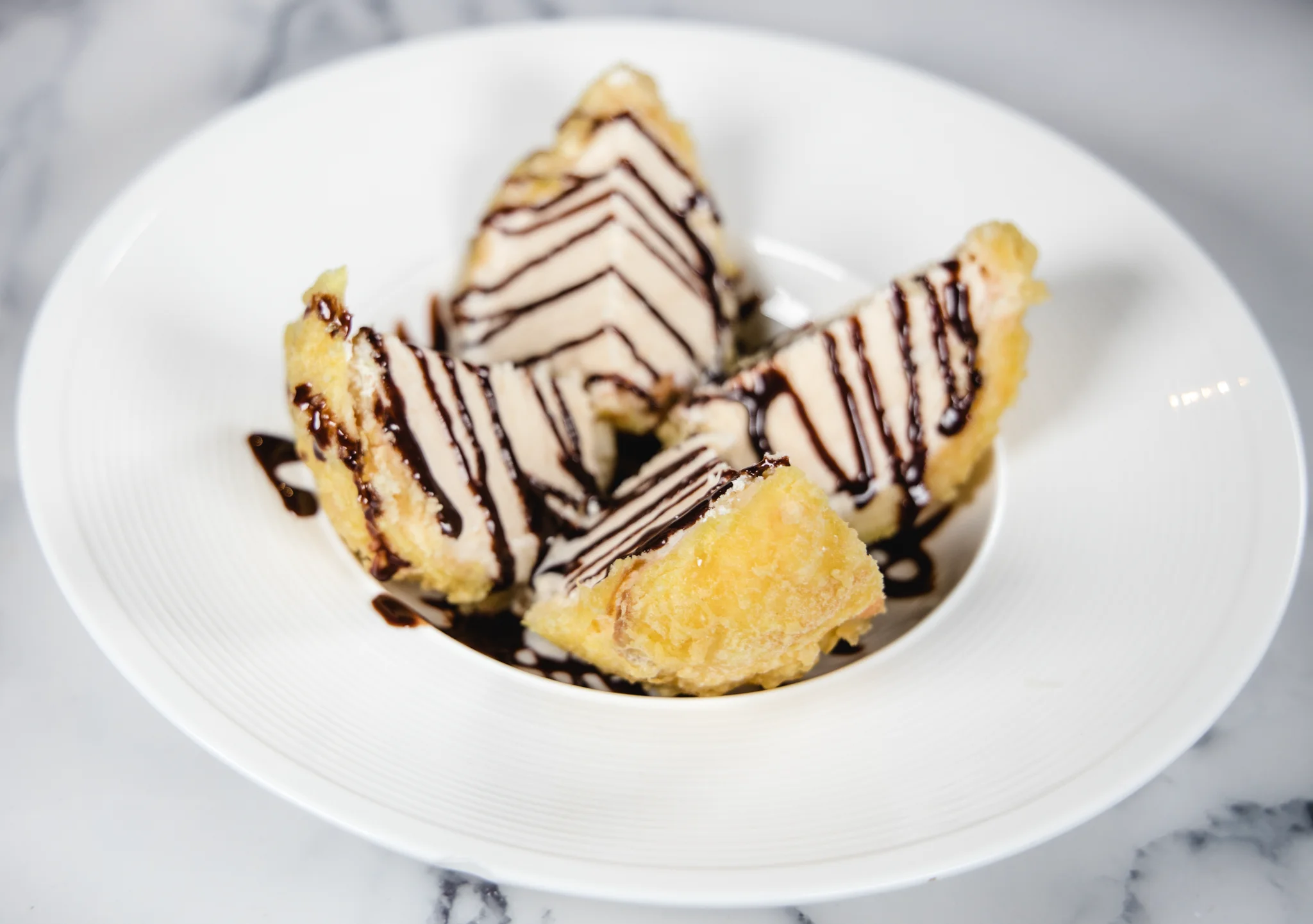 Deep-fried ice cream drizzled with chocolate sauce