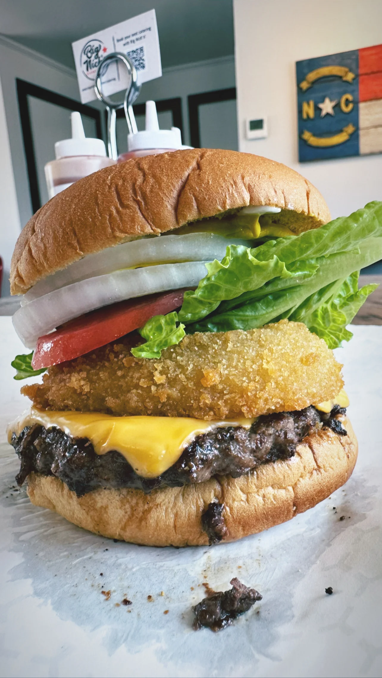A delicious burger with toppings served on a wooden table.
