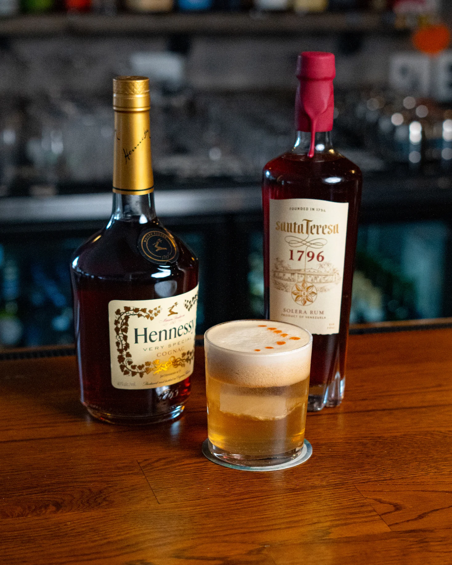 Cocktail with Hennessy and rum on a wooden bar counter