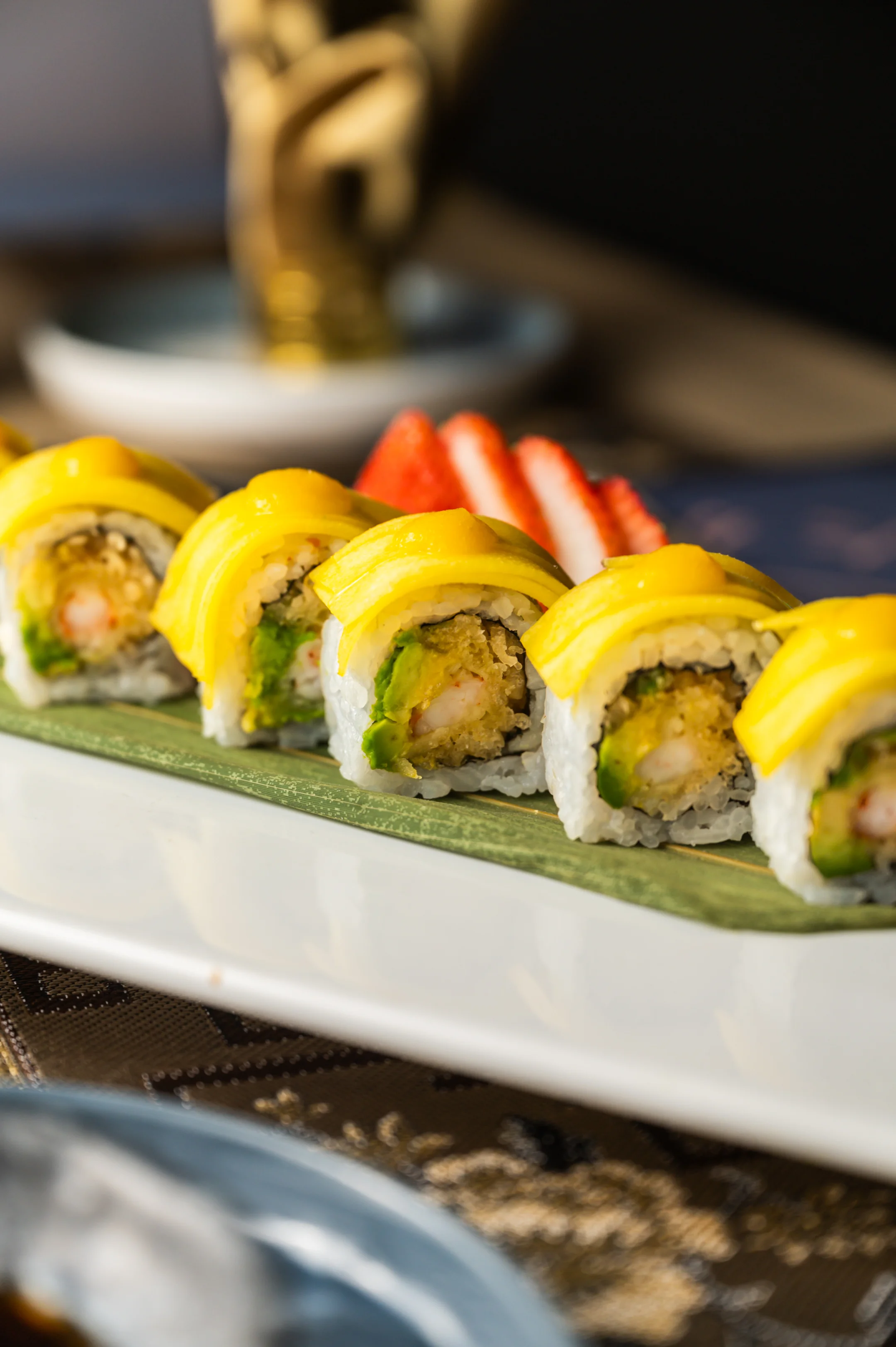 Colorful sushi roll with mango topping, a fusion of Japanese cuisine