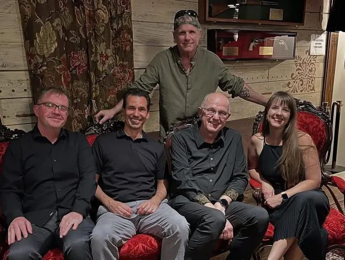 Group of friends posing on a vintage couch in a cozy restaurant setting