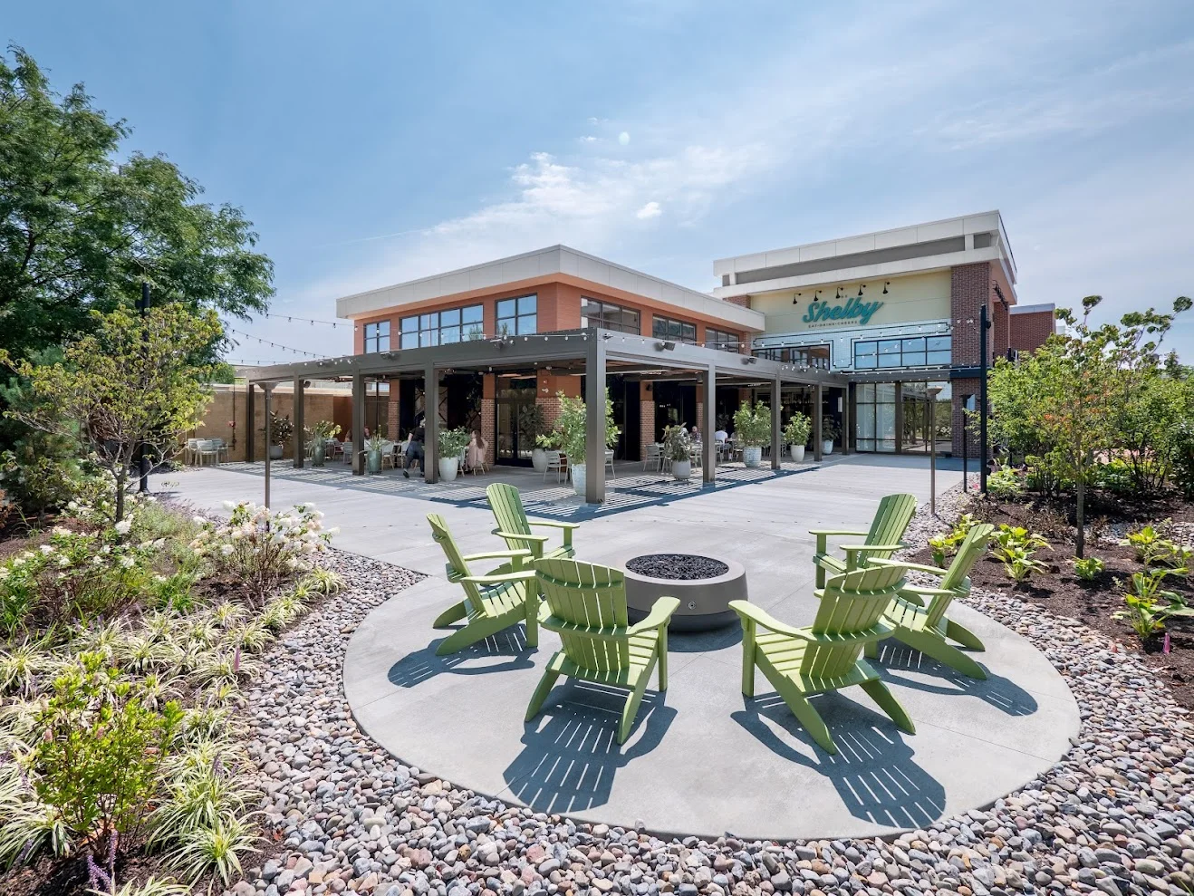 Modern restaurant exterior with outdoor seating and greenery