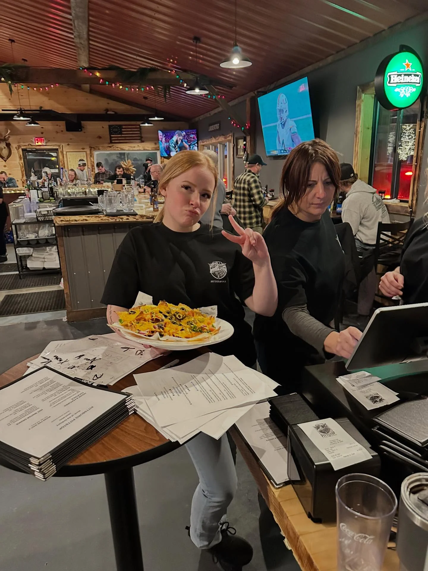 Plate of nachos served in a lively bar setting