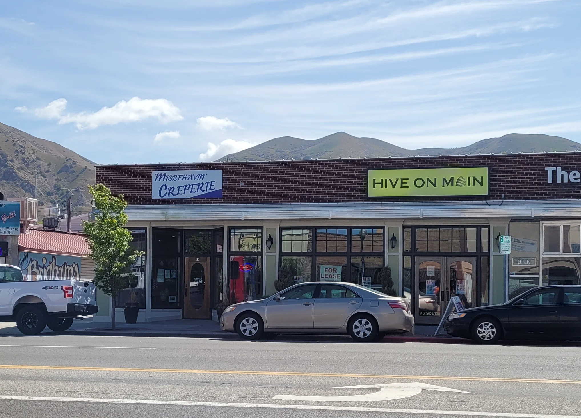 Commercial street view with shops and mountains in the background