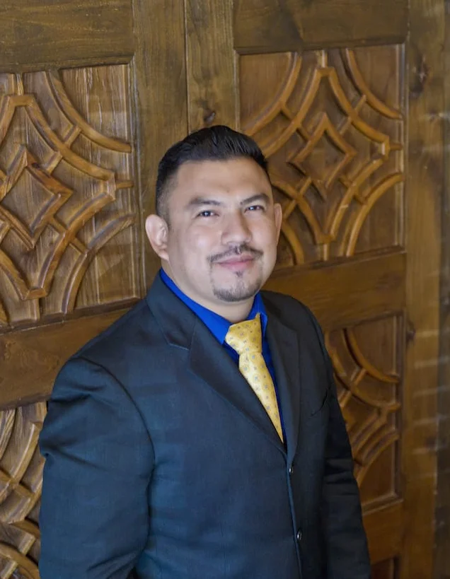 Professional man in a suit posing against a wooden backdrop