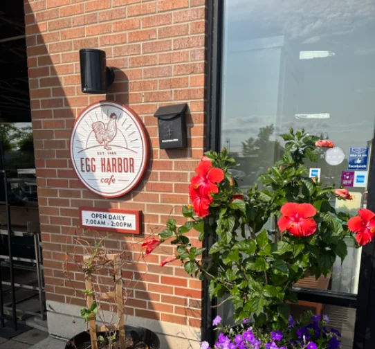 Exterior of Egg Harbor Cafe with flowers and sign