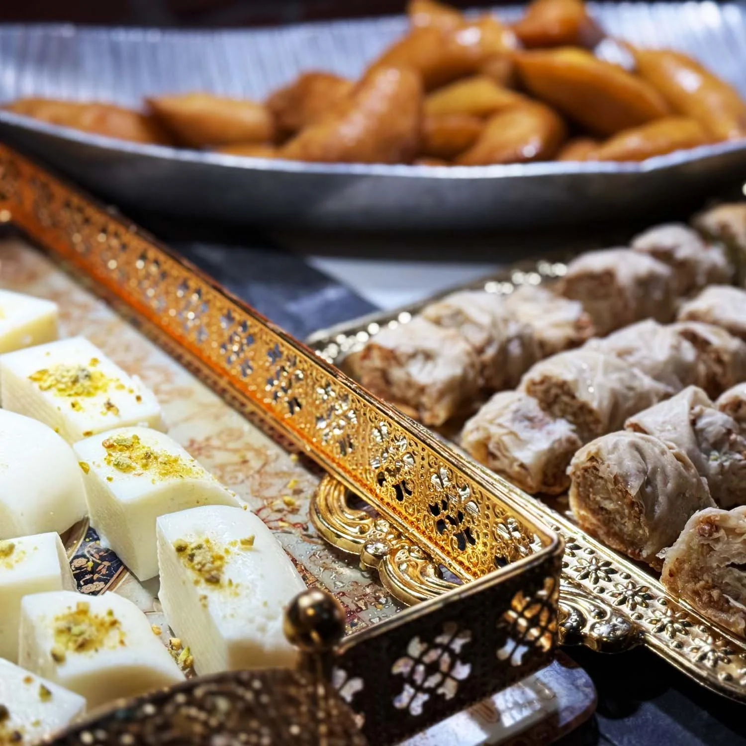 Assorted Middle Eastern sweets including baklava and kunafa
