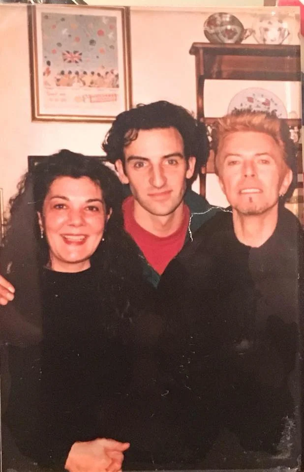 Three people posing together in a cozy indoor setting