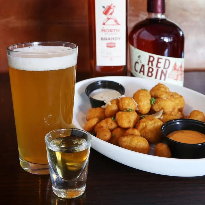 Crispy cheese curds with beer and spirits in a cozy bar setting
