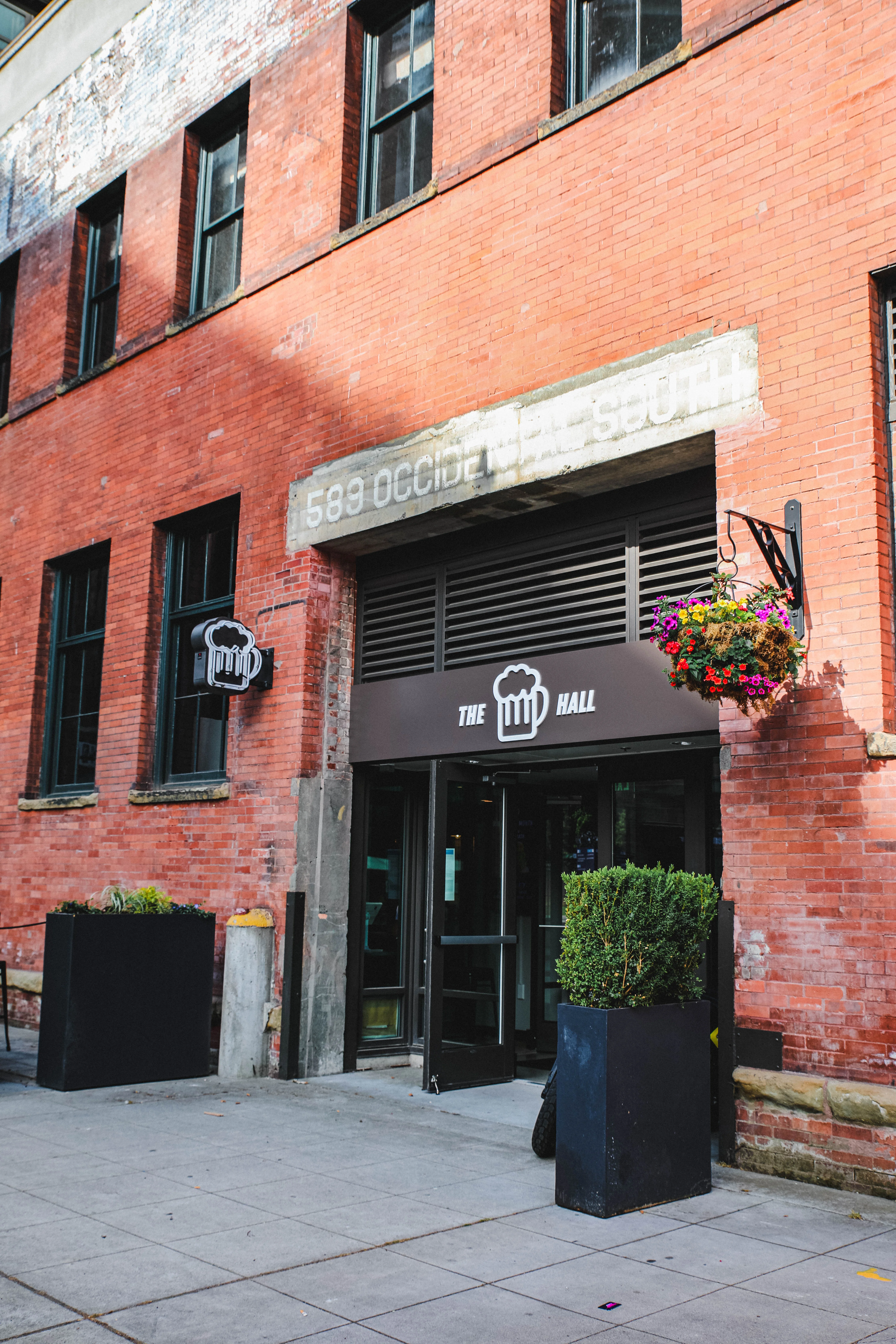 Entrance of The Hall restaurant with brick facade and modern signage