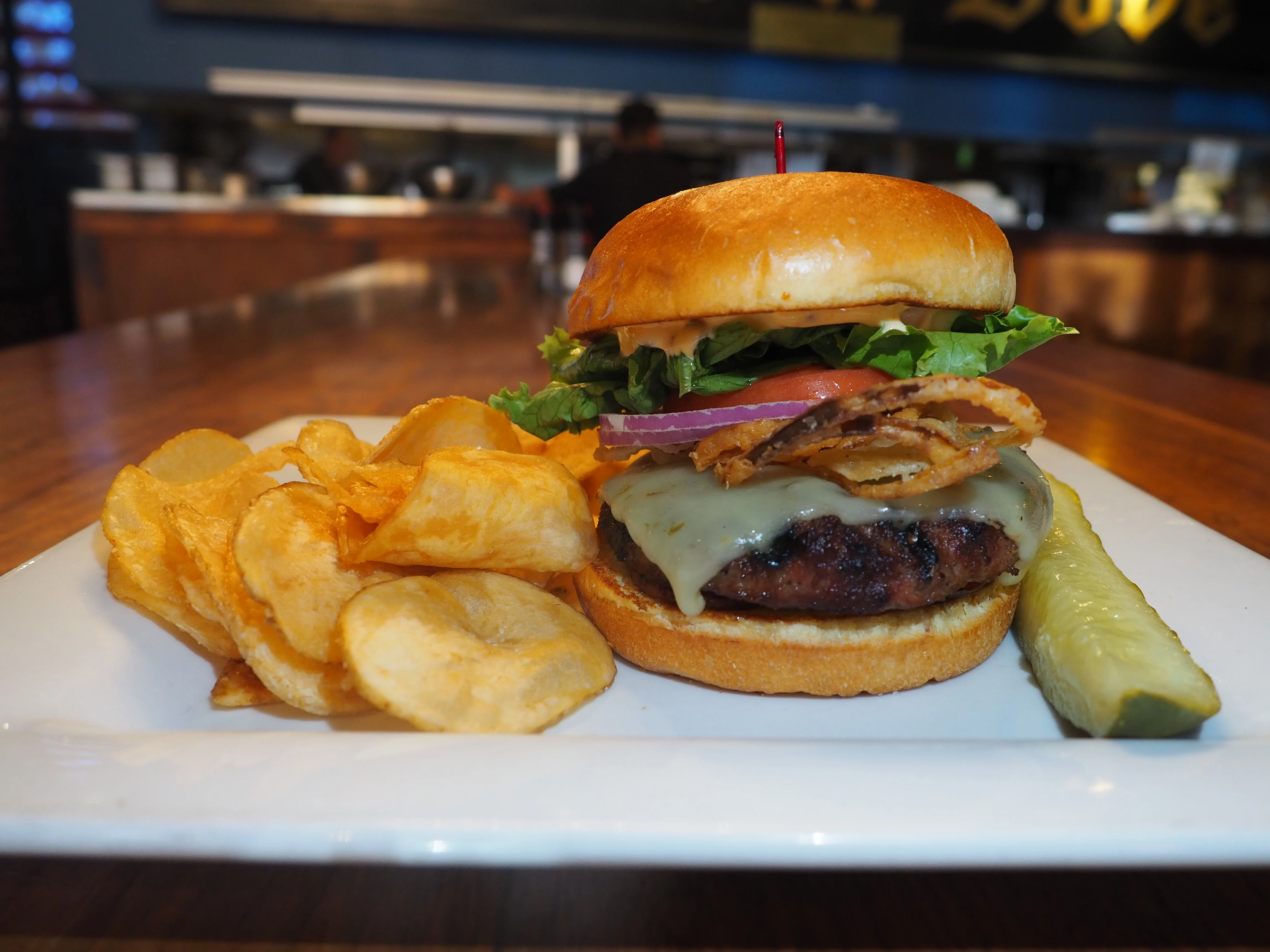 Juicy cheeseburger with crispy chips and pickles