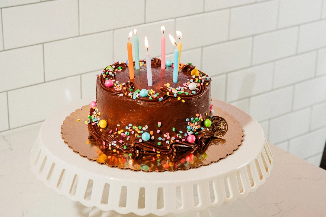 Colorful birthday cake with candles and sprinkles