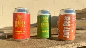 Three craft beer cans on a wooden surface