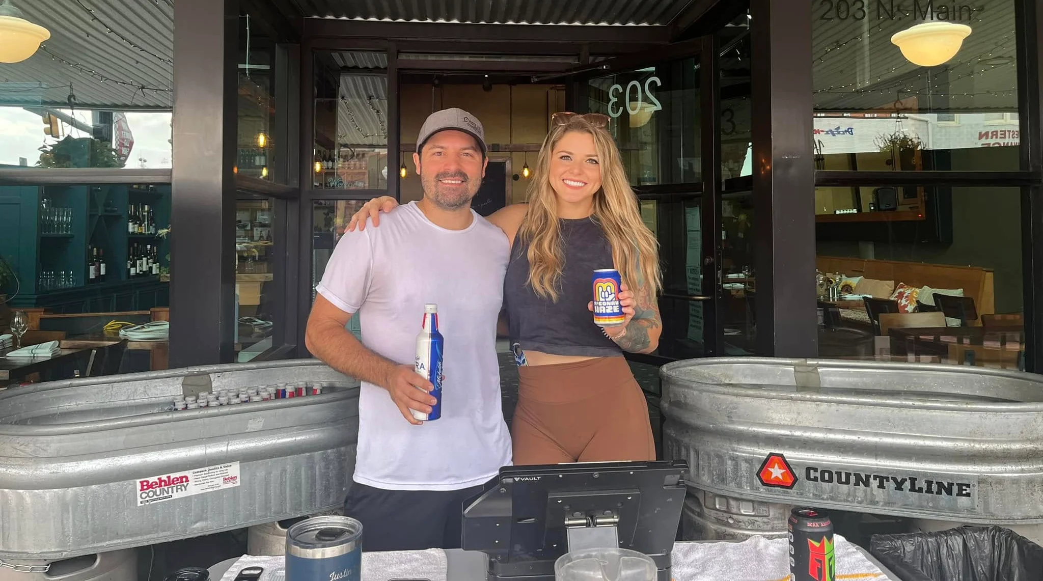 Friendly bartenders at a vibrant restaurant entrance