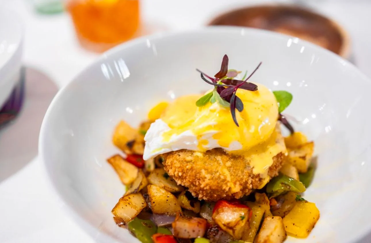 Poached egg on a crispy base with vegetables and hollandaise sauce.